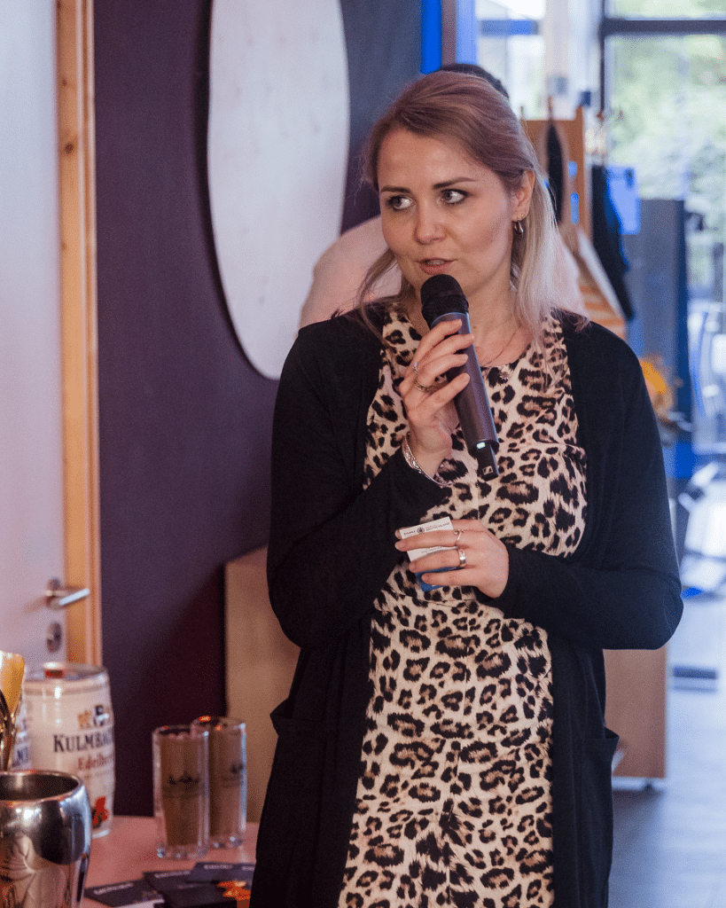 Anna-Maria vom Porschezentrum Bayreuth spricht ins Mikrofon bei der Abendveranstaltung des Charity-Golfturniers von Round Table 98 Bayreuth